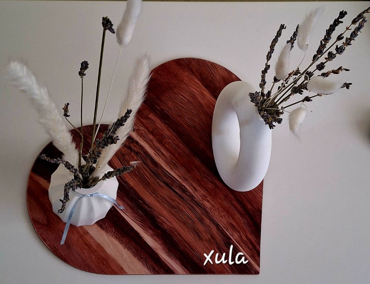 Composición XULA con flor seca sobre corazón de madera